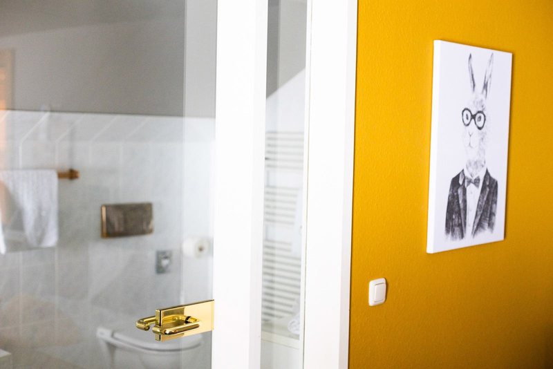 Blick ins Bad, Bild eines Hasen an gelber Wand in einem Scesa-Zimmer