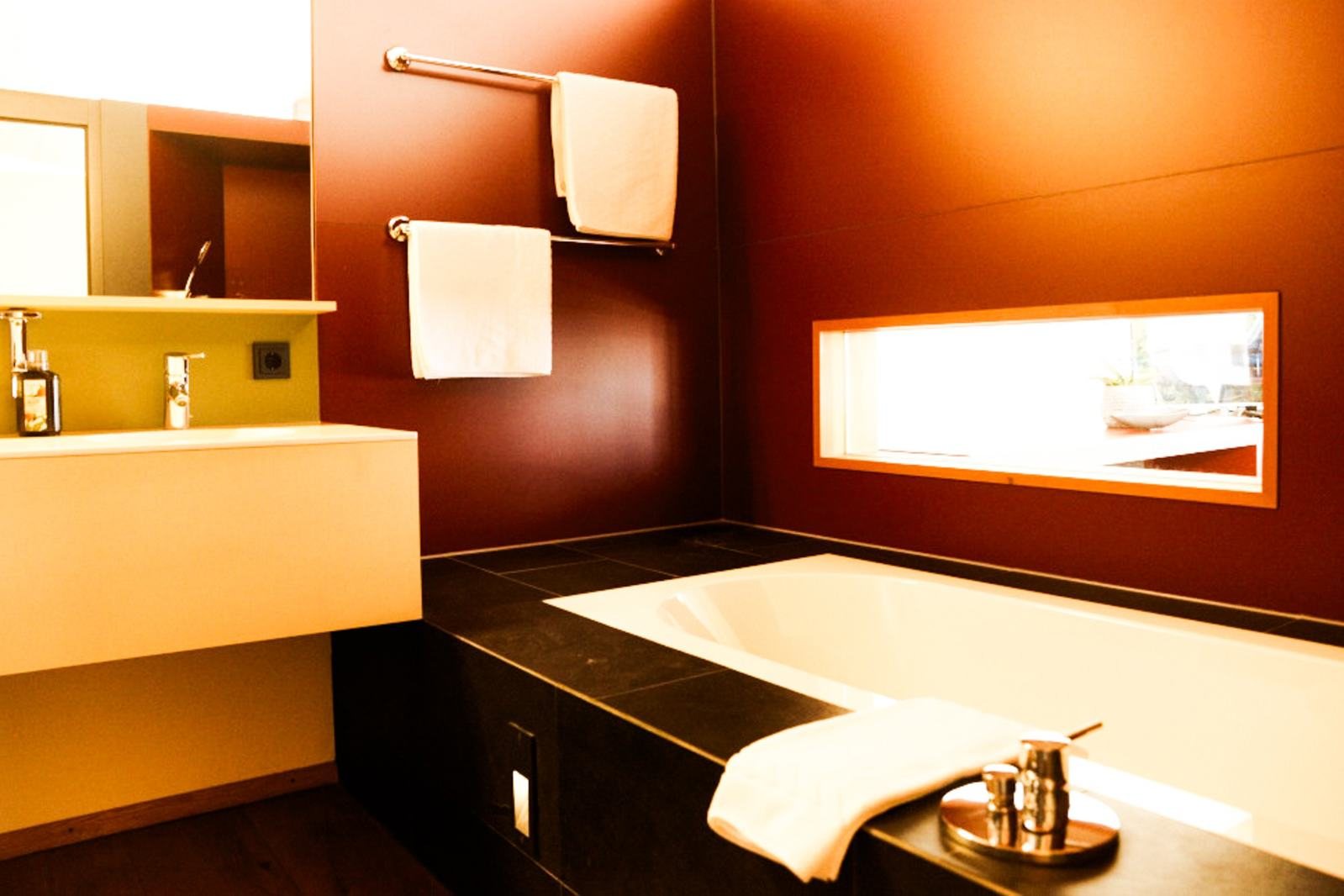 Suite Tschappina · Badewanne mit Blick durchs Fensterband
