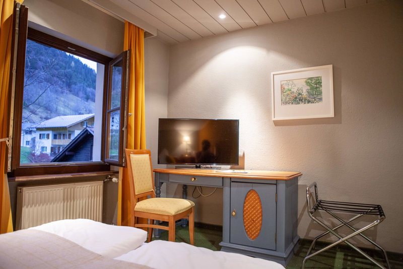 Scesa Medium · Bett, Fenster mit Bergblick und Schreibtisch