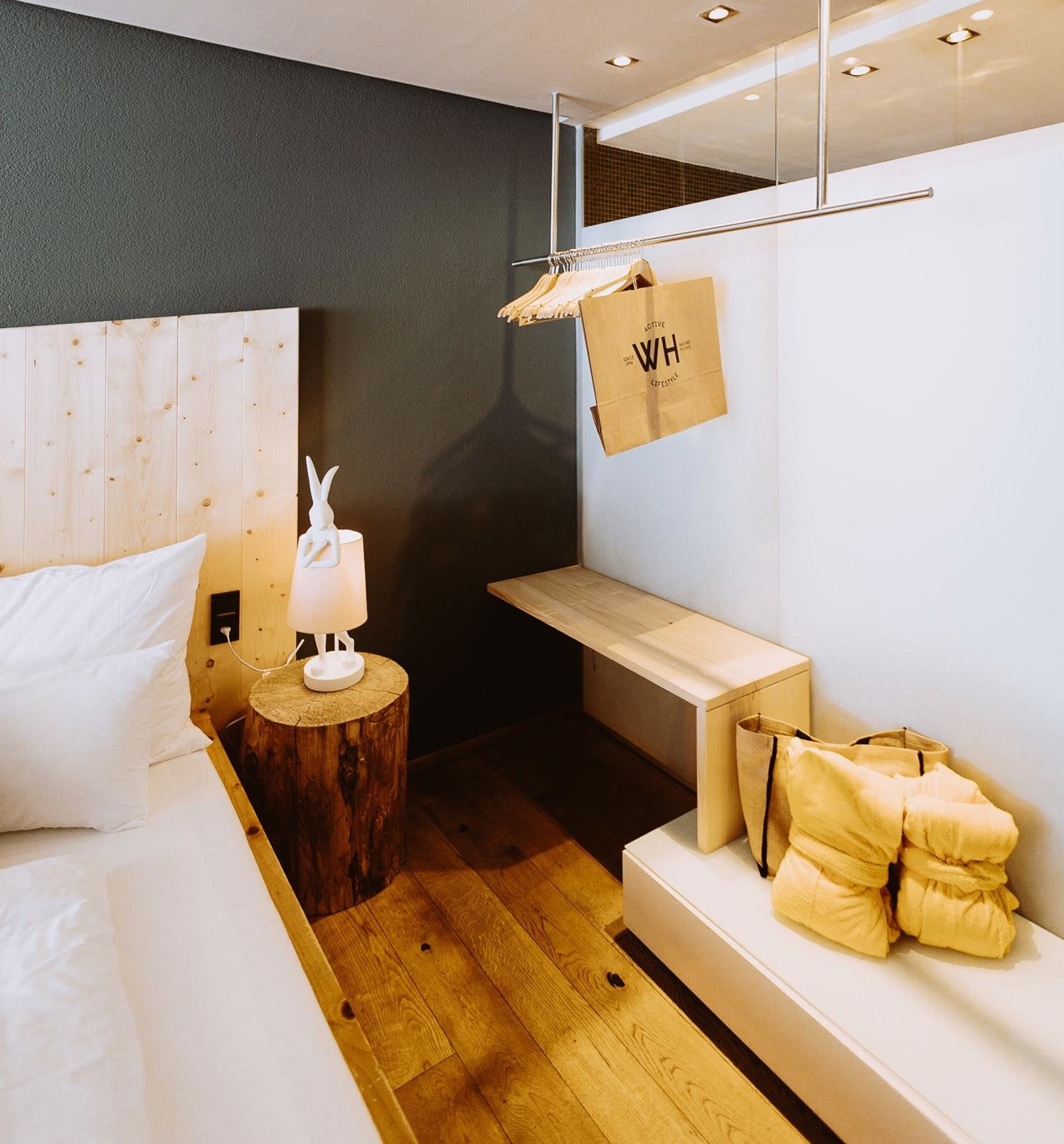 Bett und Sitzbank mit gelben Handtüchern in einem Alpinista-Zimmer im Walliserhof