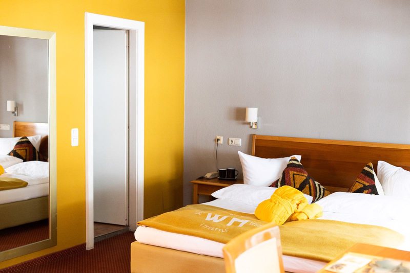 Scesa Medium Plus · Doppelbett vor gelber Wand