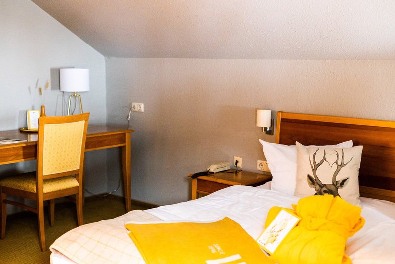 Doppelbett unter der Dachschräge mit Hirschkissen in einem Scesa-Zimmer
