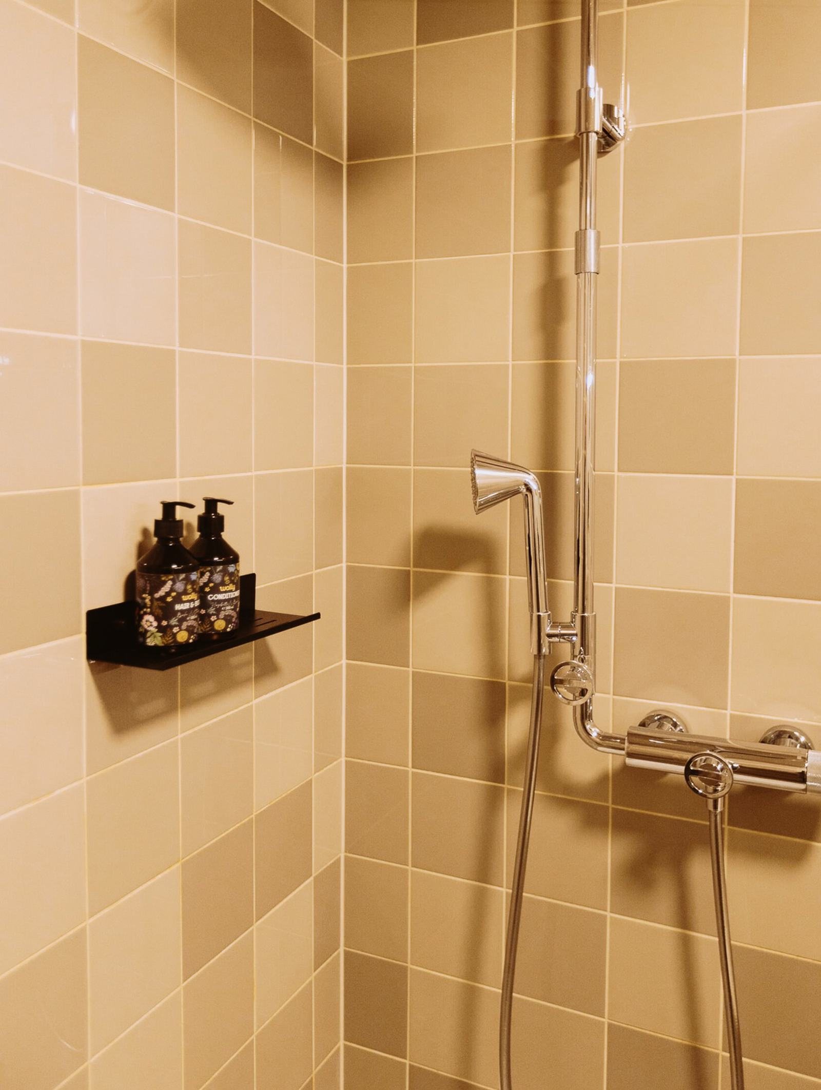 Dusche mit Fliesen in Sandtönen in einem Zimmer im Walliserhof