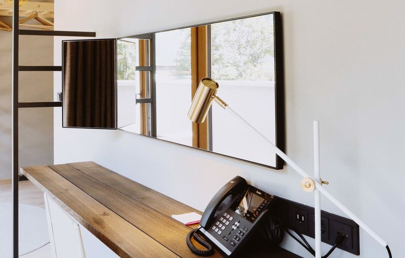 Familienzimmer Gipfelstürmer 506 · Schreibtisch mit Spiegel und Lampe am Fenster
