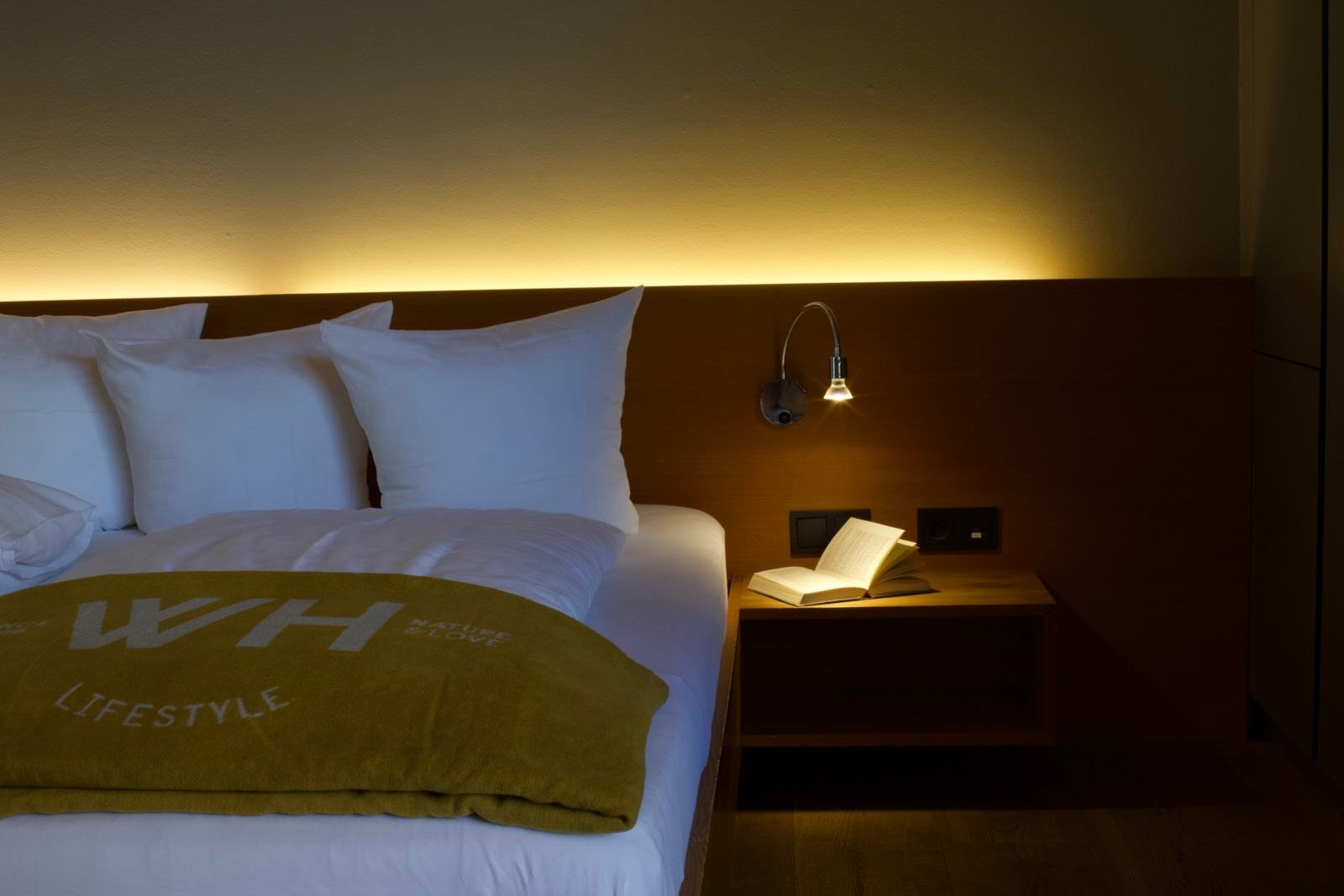 Suite Bruegga · Bett mit gelber Decke und Leselampe