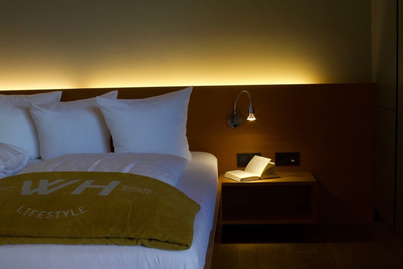 Suite Bruegga · Bett mit gelber Decke und Leselampe