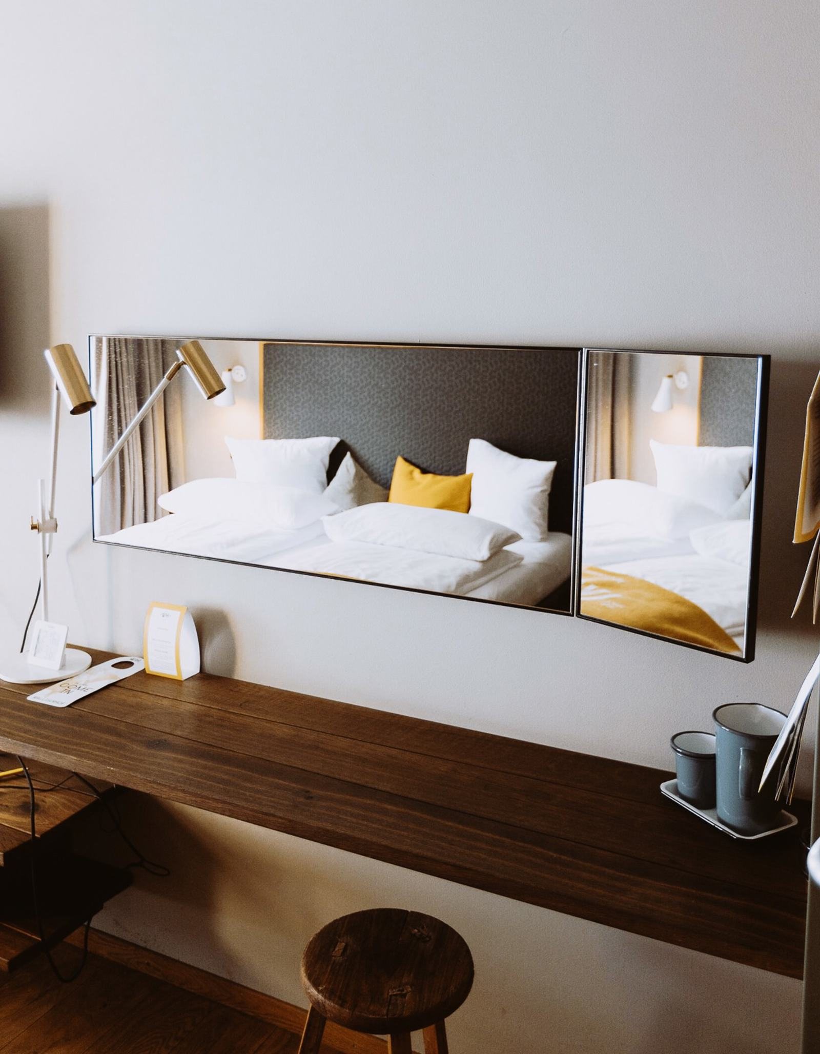 Schreibtisch mit Spiegel und Hocker in einem Gipfelstürmer-Zimmer im Walliserhof